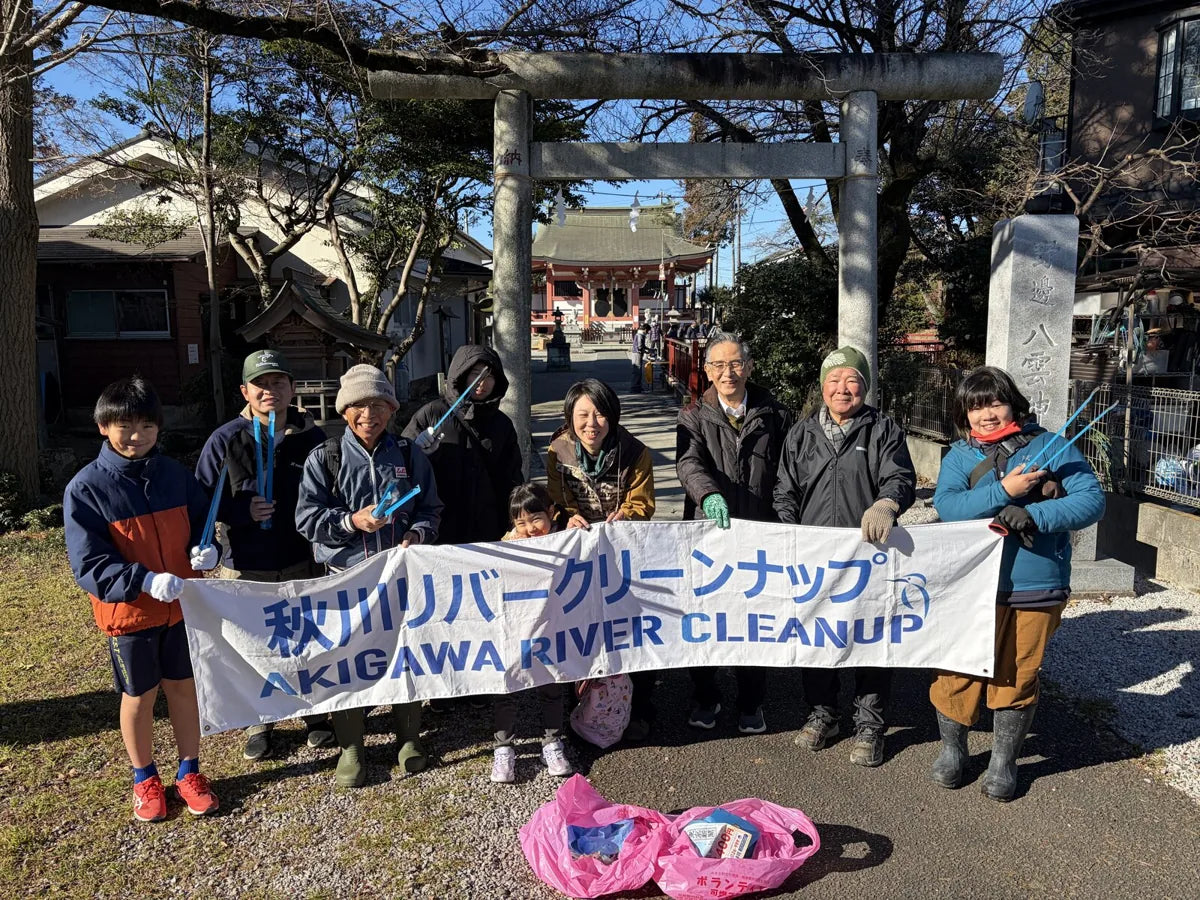 「秋川リバークリーンナップ」の横断幕を持つ参加者たち