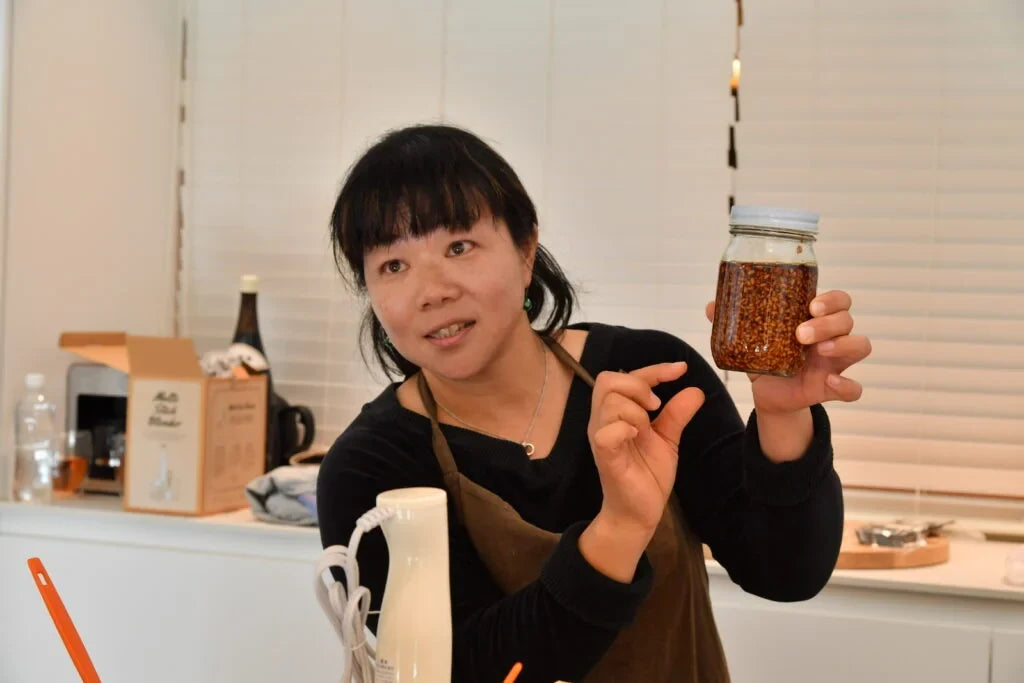 手づくりの発酵食品の瓶を見せながら話す様子